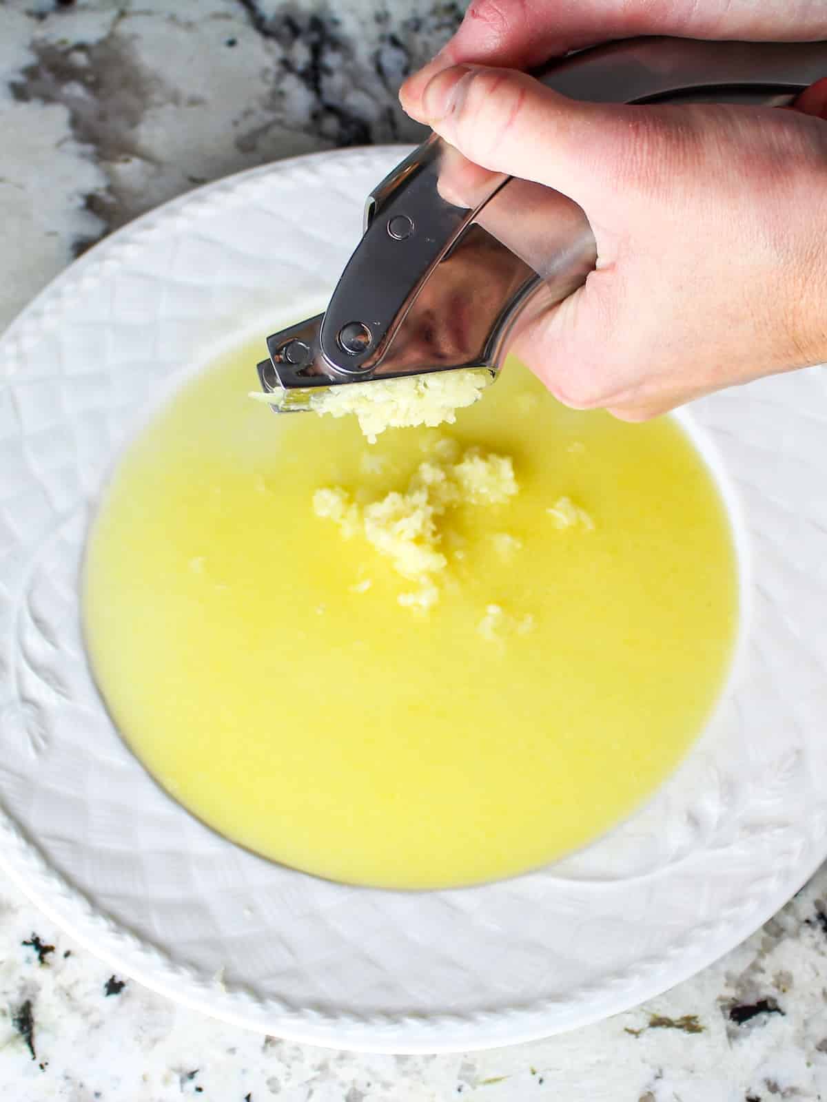 Adding fresh minced garlic to the melted butter.