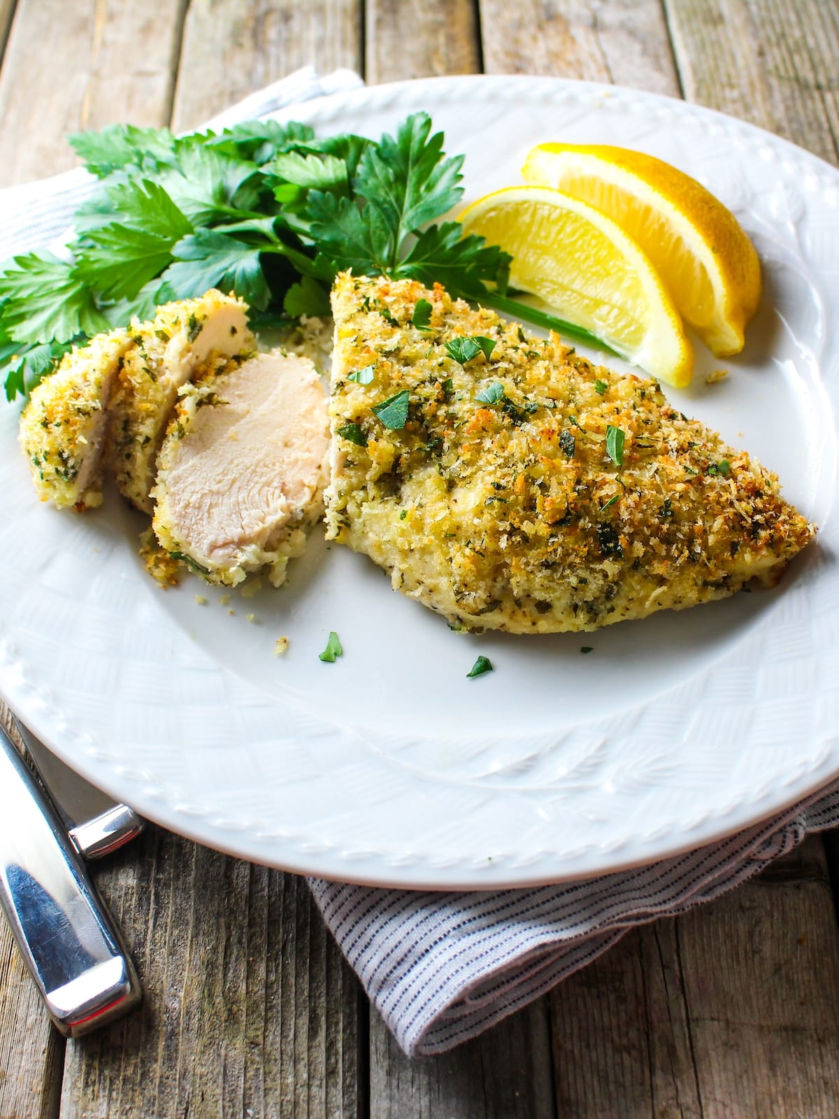 Easy oven-baked Parmesan crusted chicken sliced and plated, ready to serve.