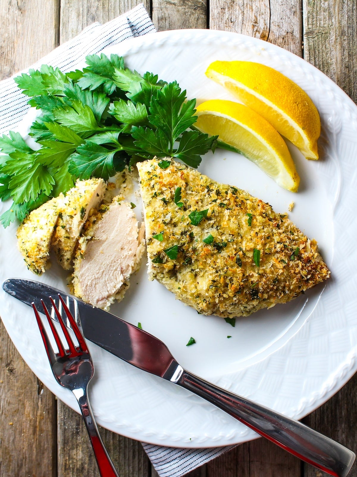Easy oven-baked Parmesan crusted chicken sliced and plated, ready to serve.