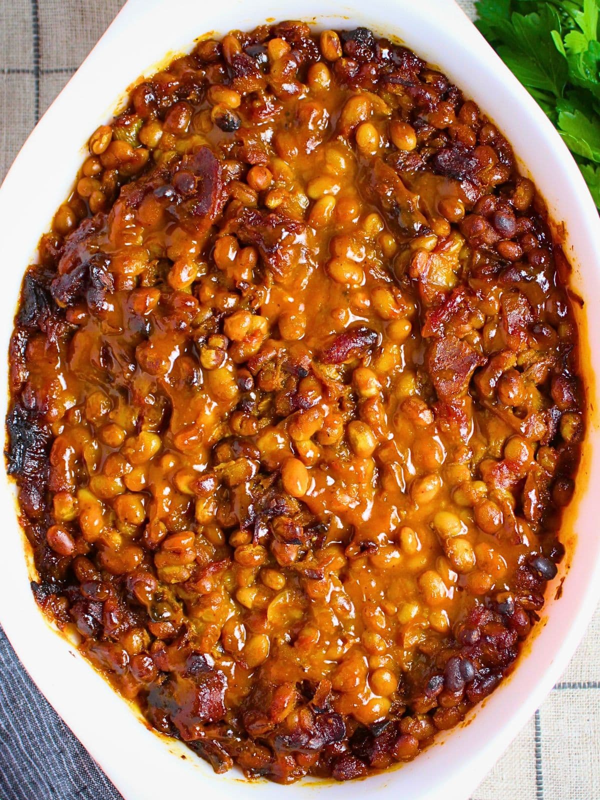 Smoky BBQ baked beans in a cast iron skillet — a classic cookout and BBQ side dish