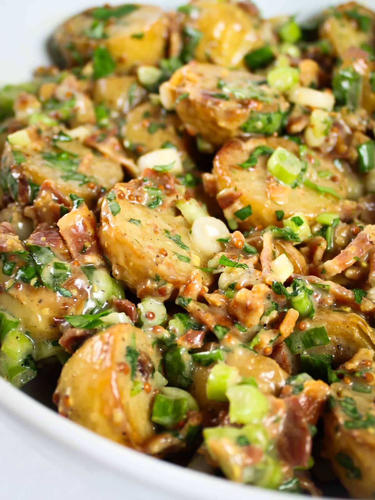Close-up of Salt and Vinegar Potato Salad with crispy bacon, green onions, parsley, and tangy mustard dressing