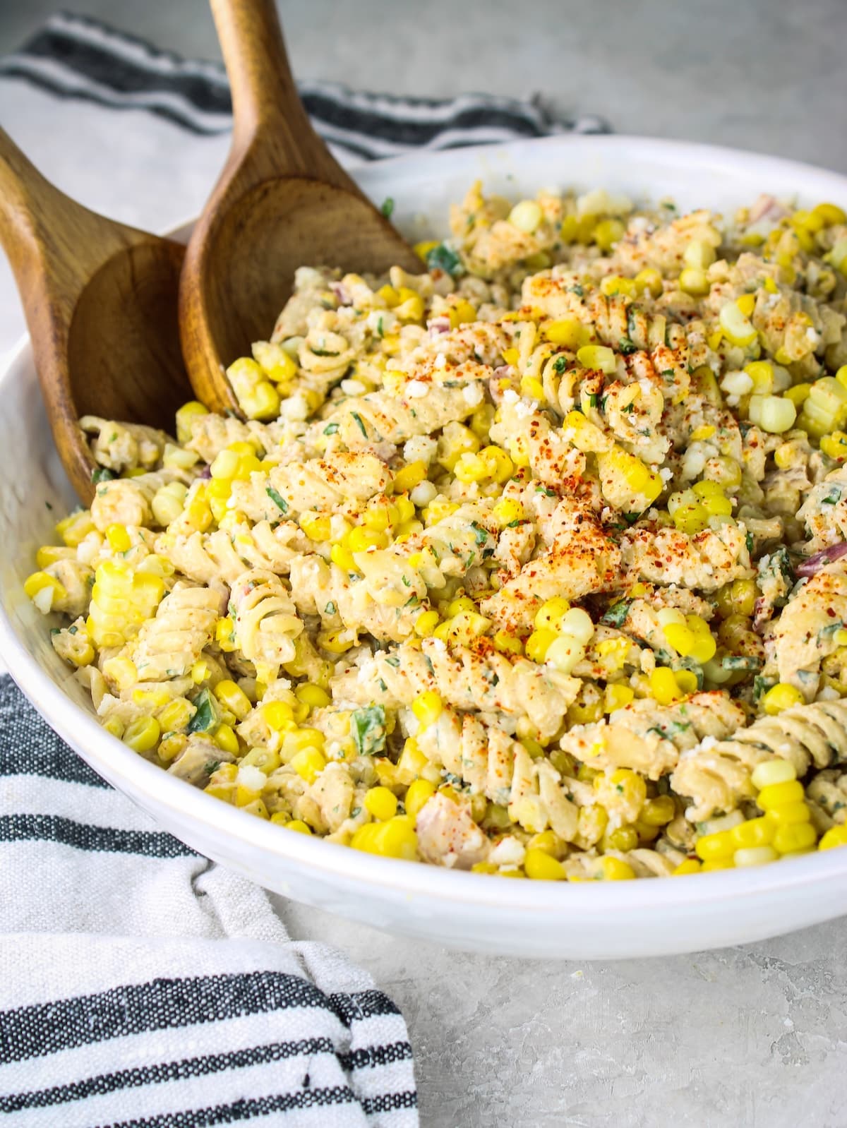 Side-angle shot of street corn pasta salad topped with tajin and cotija cheese