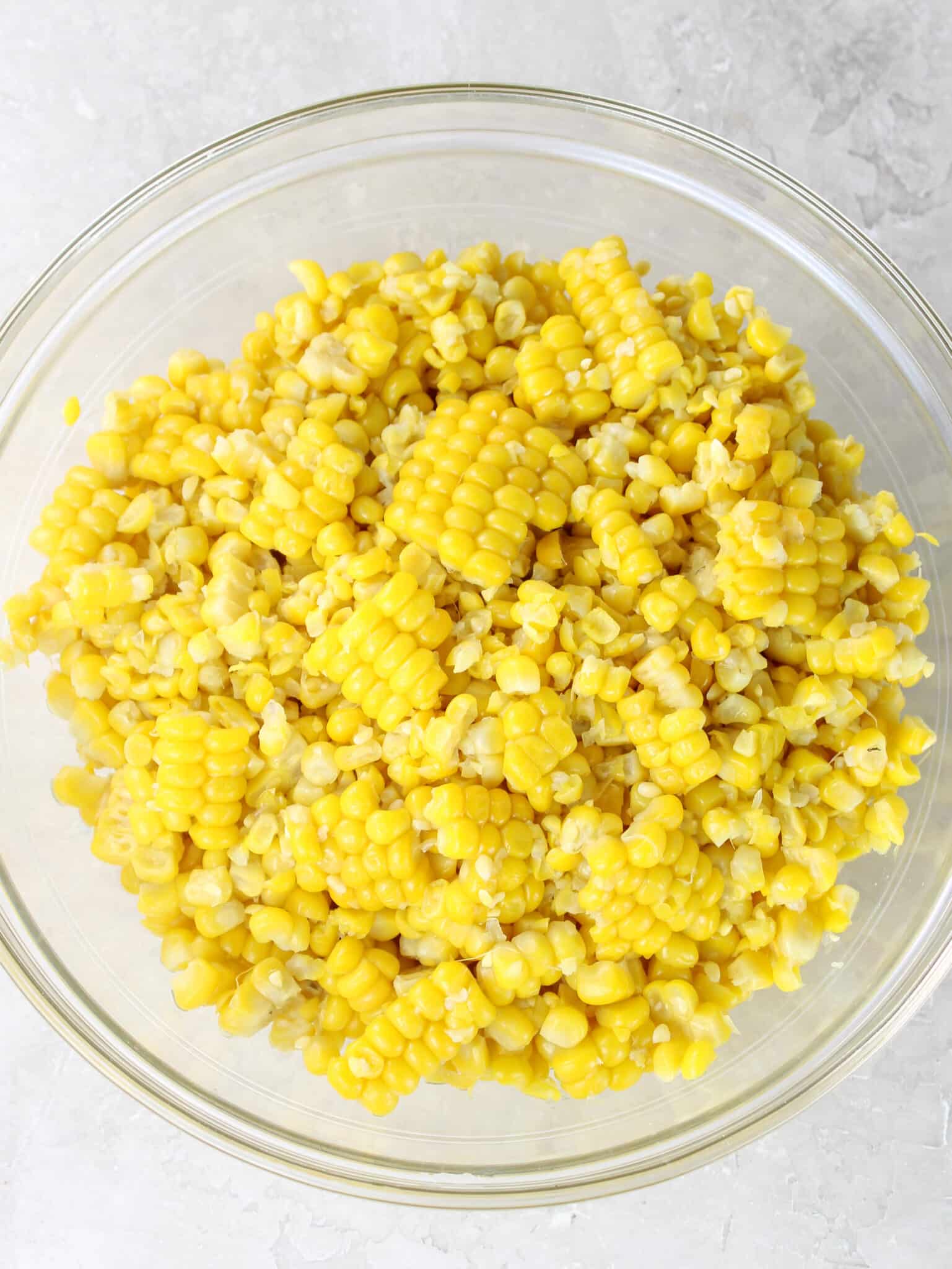 Fresh corn kernels cut off the cob in a glass bowl for Mexican street corn pasta salad