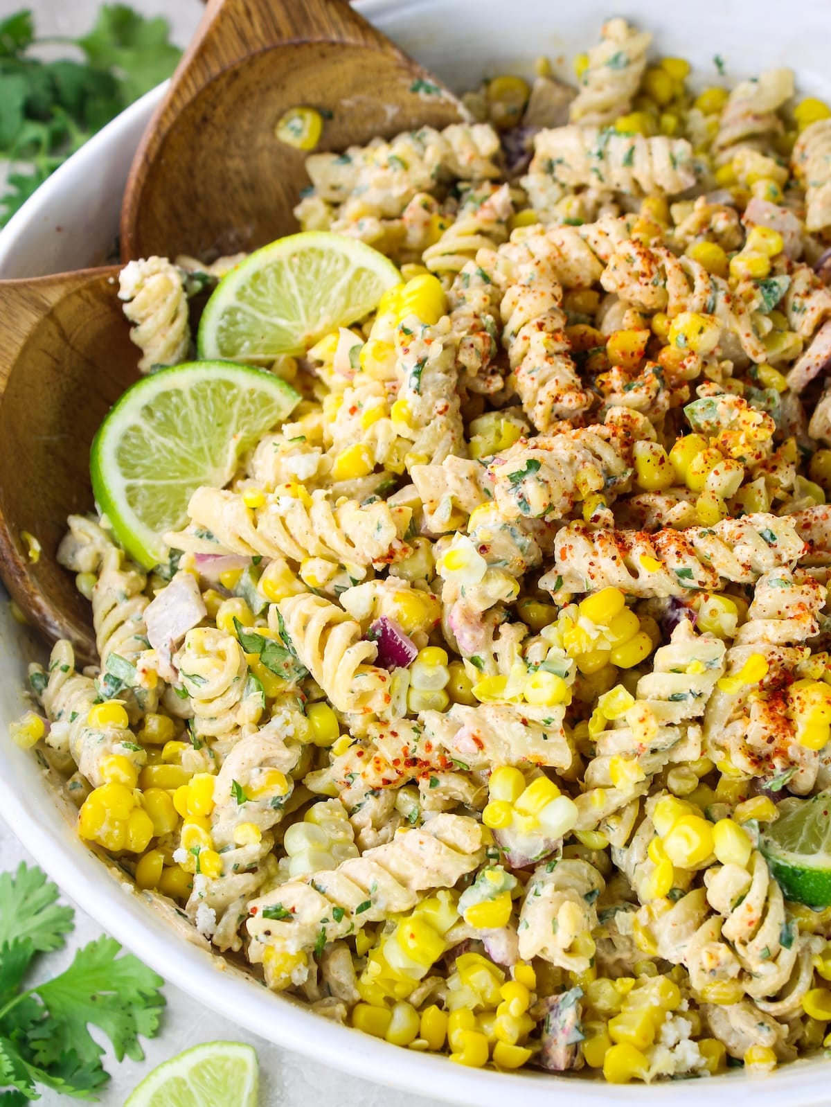 Partial bowl view of street corn pasta salad with cotija cheese and jalapeño in the background